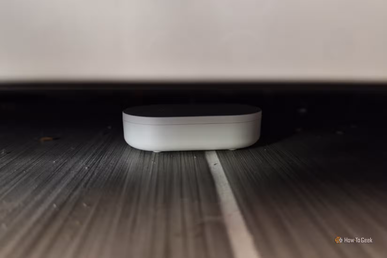 An IKEA KLIPPBOK water sensor underneath a refrigerator.