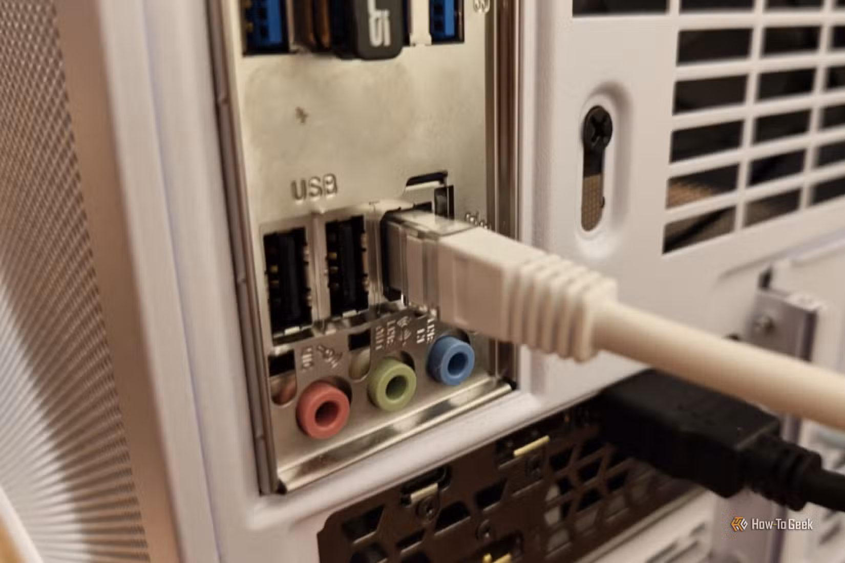 An Ethernet cable plugged into the back of a desktop PC.