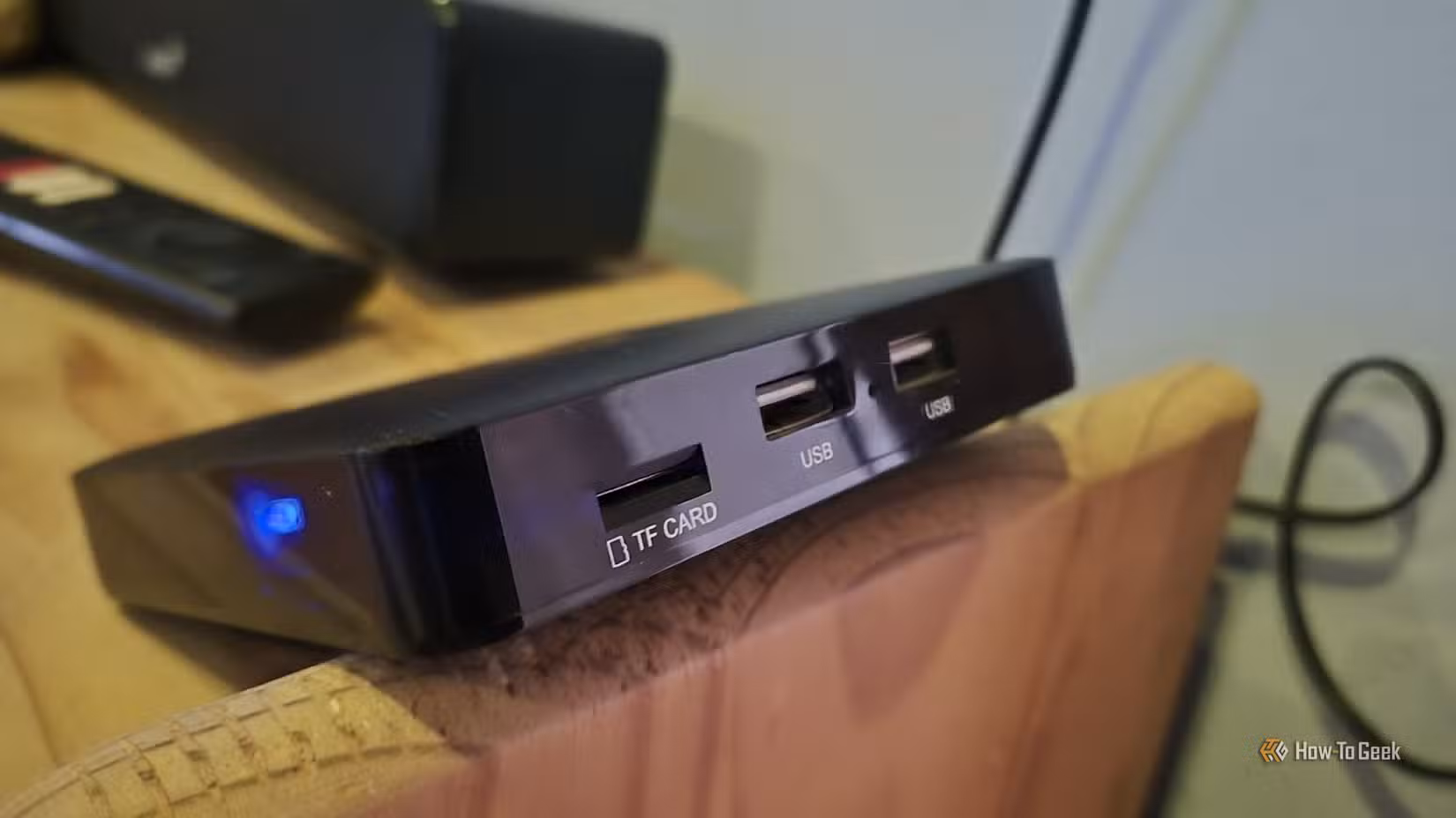 An Ematic dv8235 Android TV box balancing on the edge of a bookshelf 