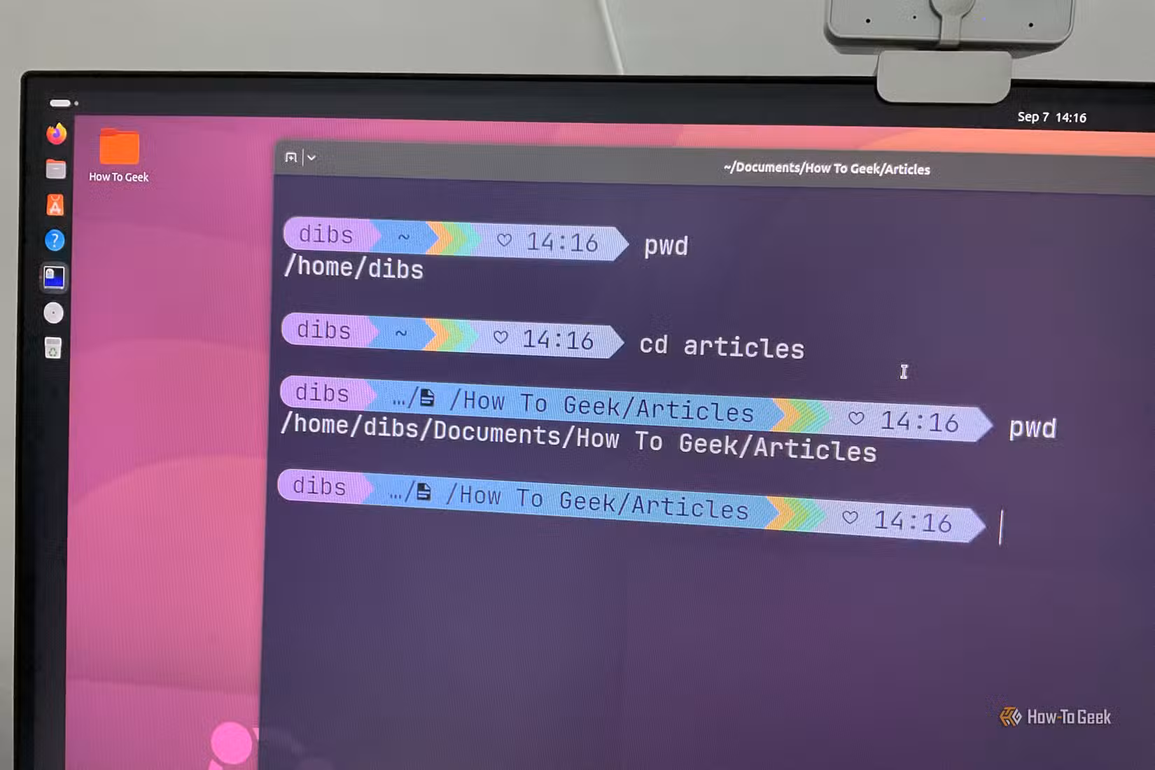 A computer monitor with Ubuntu running and the terminal showing cd and pwd command.