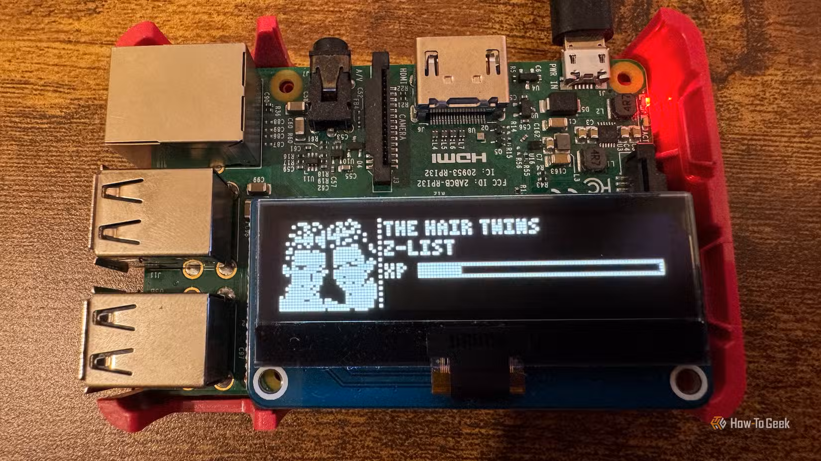 A Raspberry Pi with an OLED screen displaying a Z-list Tamagotchi character.
