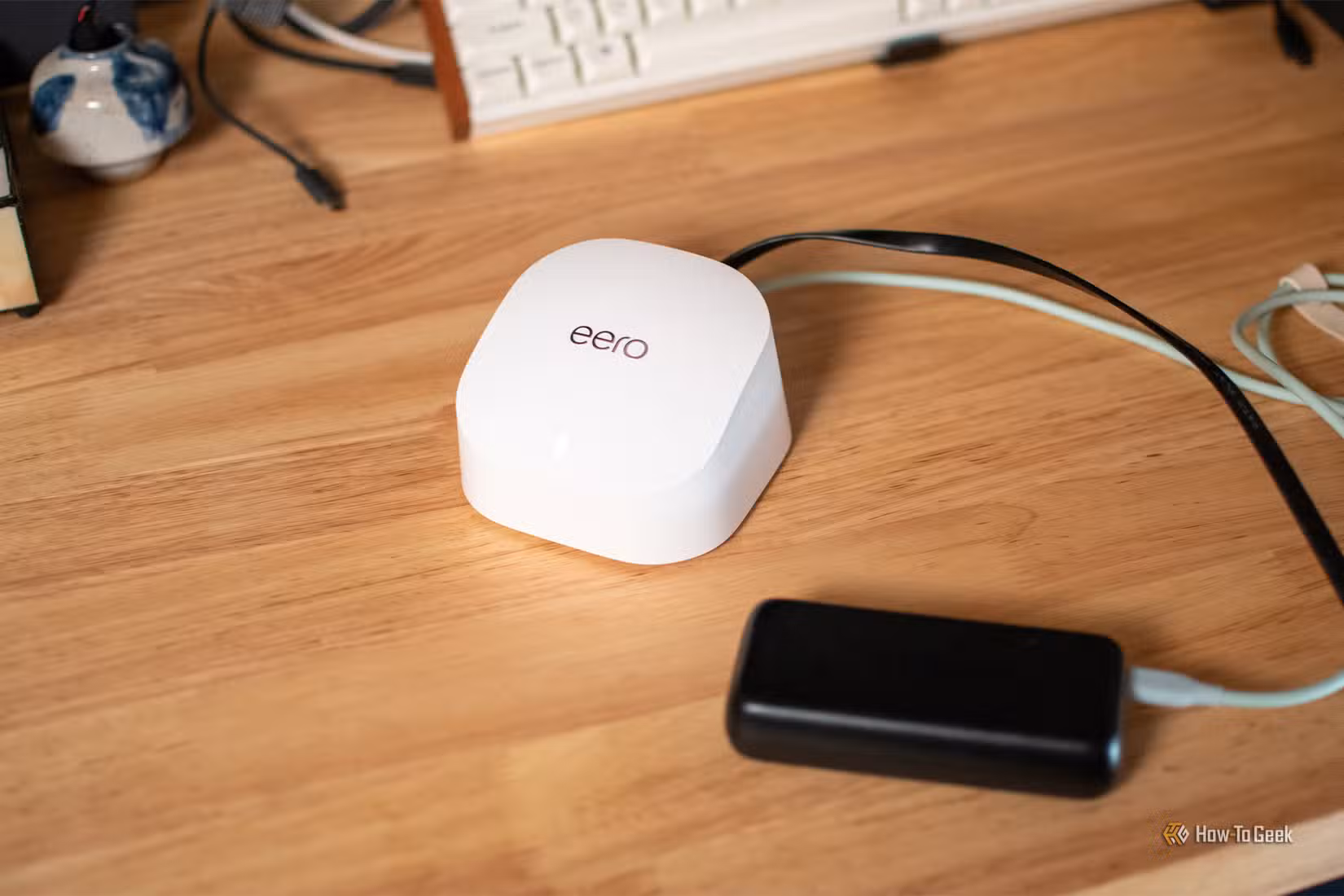 A top-down view of an Eero Wi-Fi router and power bank.