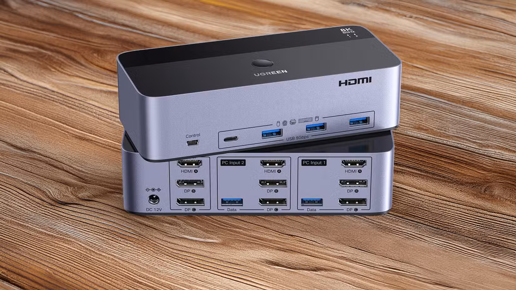A UGREEN KVM Switch sitting on a wooden table.