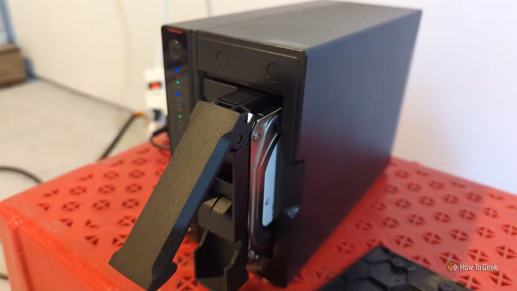 An Asustor NAS with one hard drive pulled partially out of the bay.