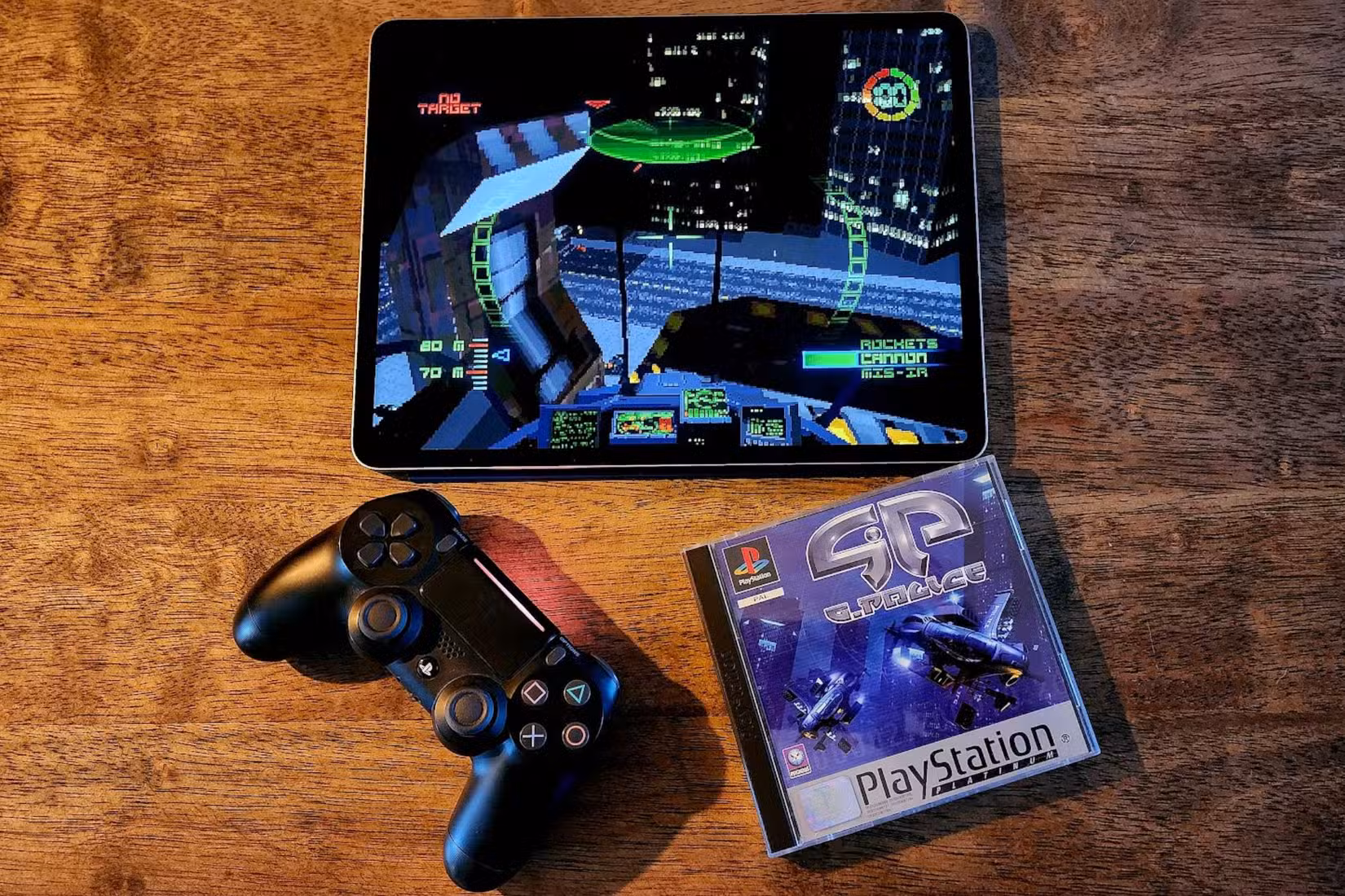 An iPad running G-Police next a  physical original copy of the game and a PS4 controller