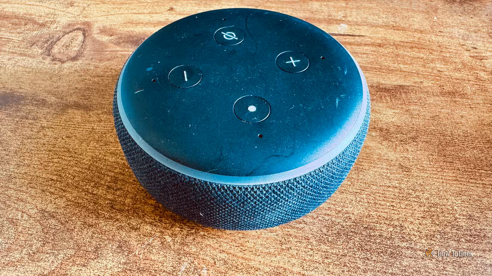 An old third-generation Echo Dot on a desk.