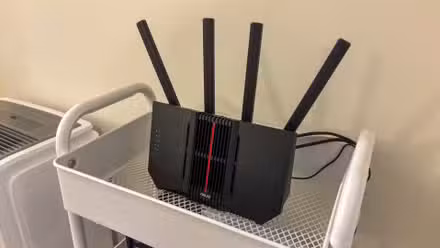 An ASUS router on a shelf.