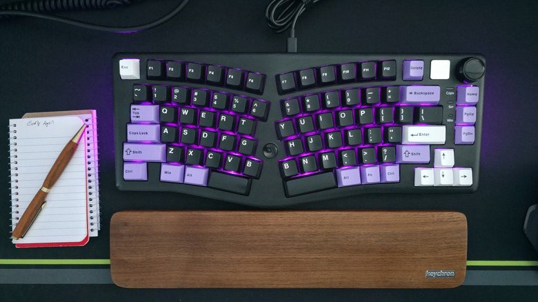 LeoBog Alice A75 split-layout ergonomic mechanical keyboard on desk with Keychron wristpad, a pen and spiral notebook.