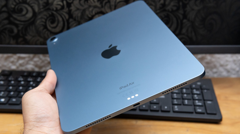 A man holding an iPad Air with the charging port visible.