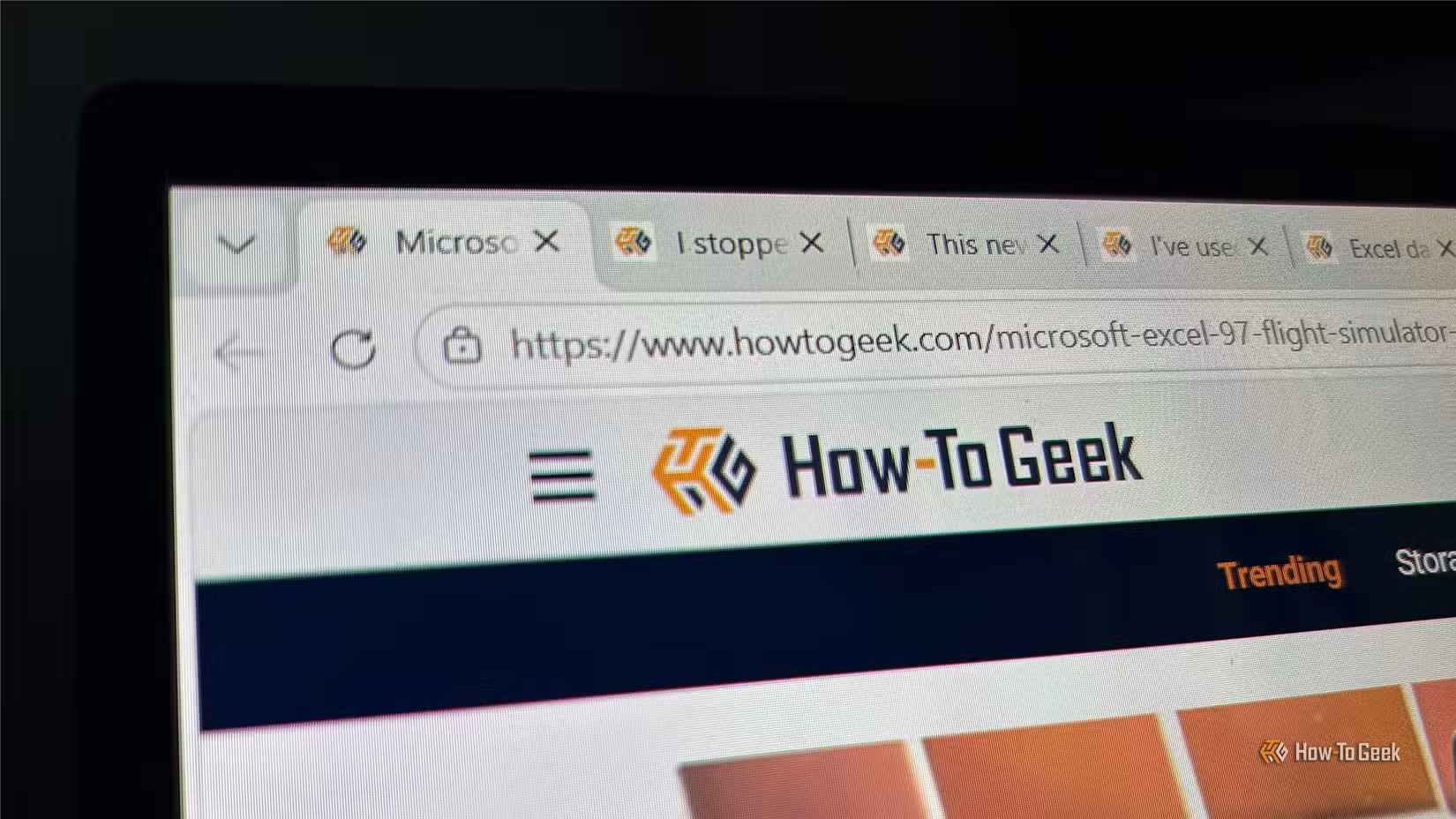 In Microsoft Edge, the How-To Geek website is open alongside several tabs in the browser.