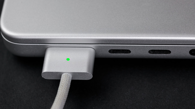 MagSafe cable plugged into a MacBook, which also features USB-C ports.