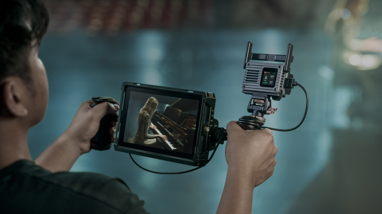 A man using the DJI SDR Transmission II system is receiving video to an Atomos monitor