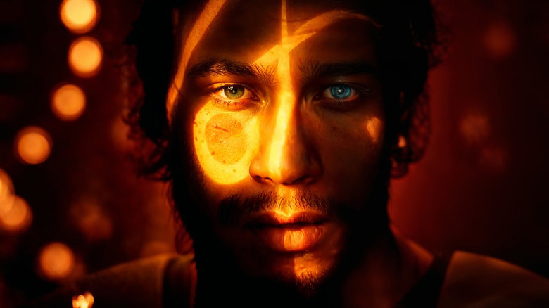 Video game screenshot of a person's face illuminated by a circle and cross lighting.