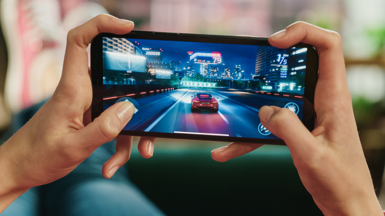A person playing a racing game on a smartphone.