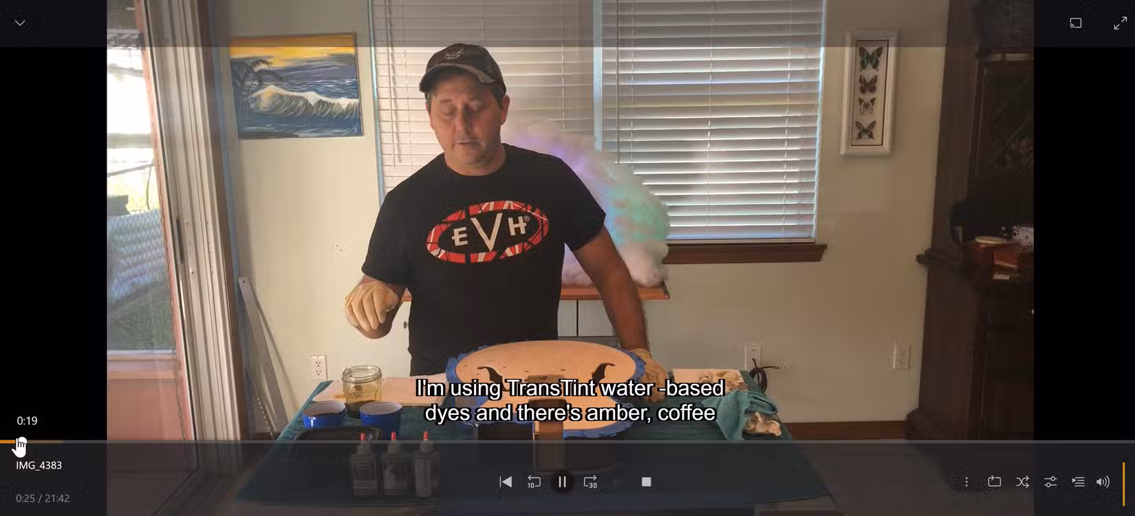 A personal guitar-finishing video plays with subtitles generated locally by Whisperer.