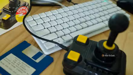 Raspberry Pi 500+ with an Amiga joystick and floppy disk.