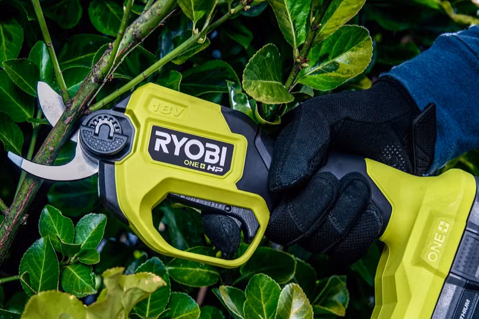 RYOBI HP brushless pruning shears cutting a branch.