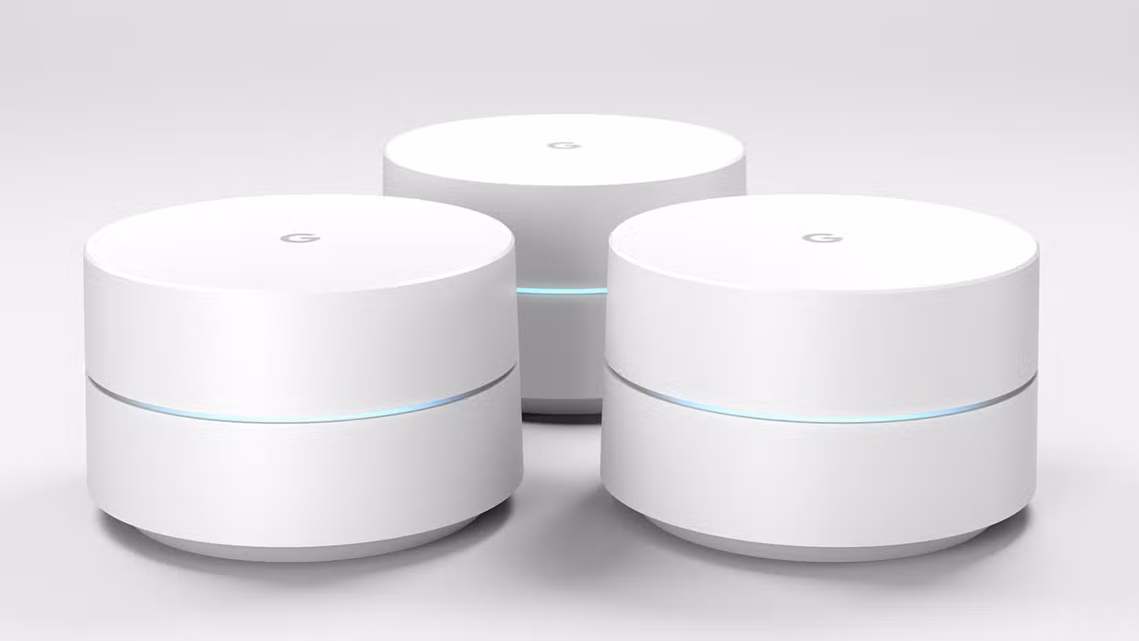 Three Google Wifi routers sitting on a table with a white background.