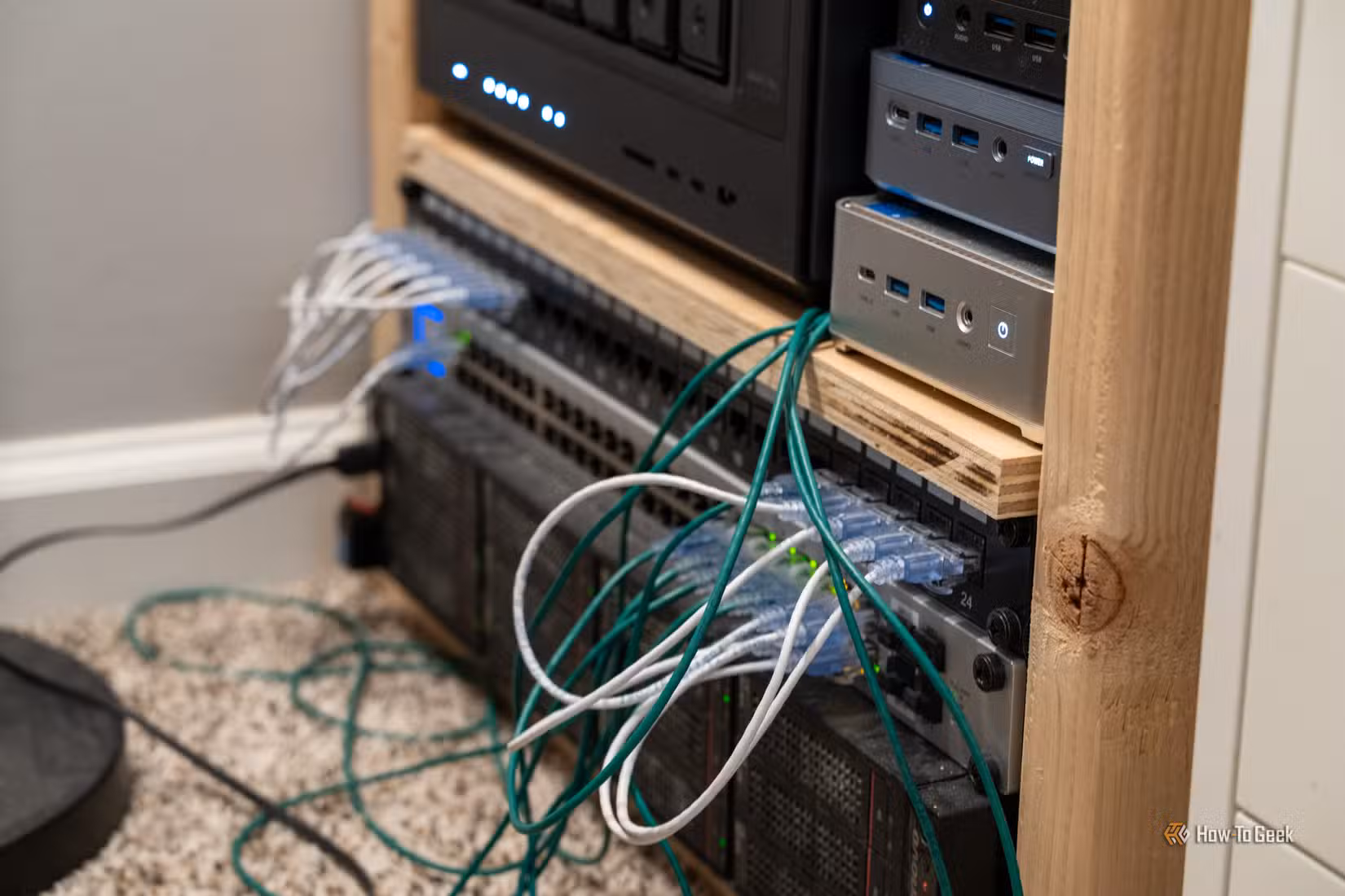 UniFi US-48-500W managed PoE network switch in rack with green and white Ethernet cables.