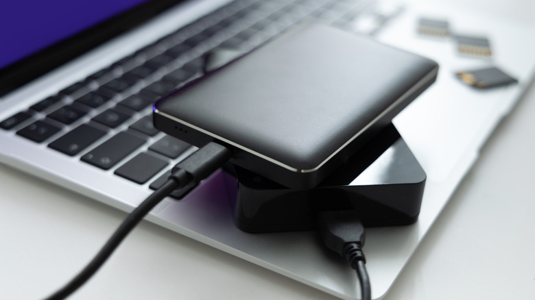 External hard drives connected to a laptop with USB cables.