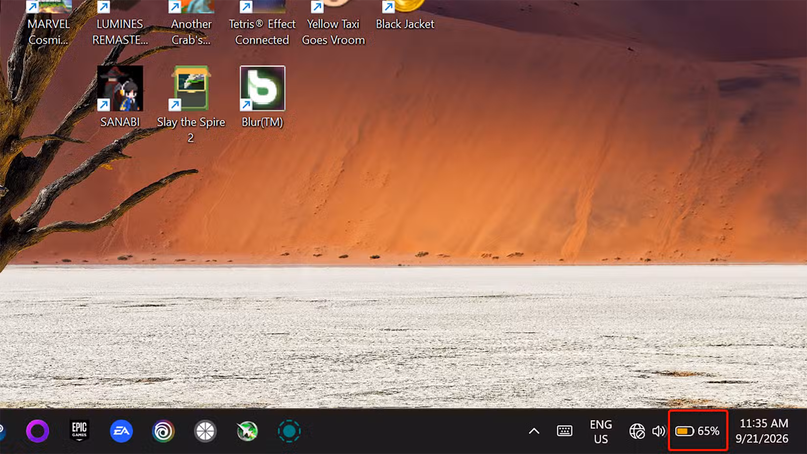 Windows 11 system tray with the battery icon turned orange, indicating that energy saver is enabled.